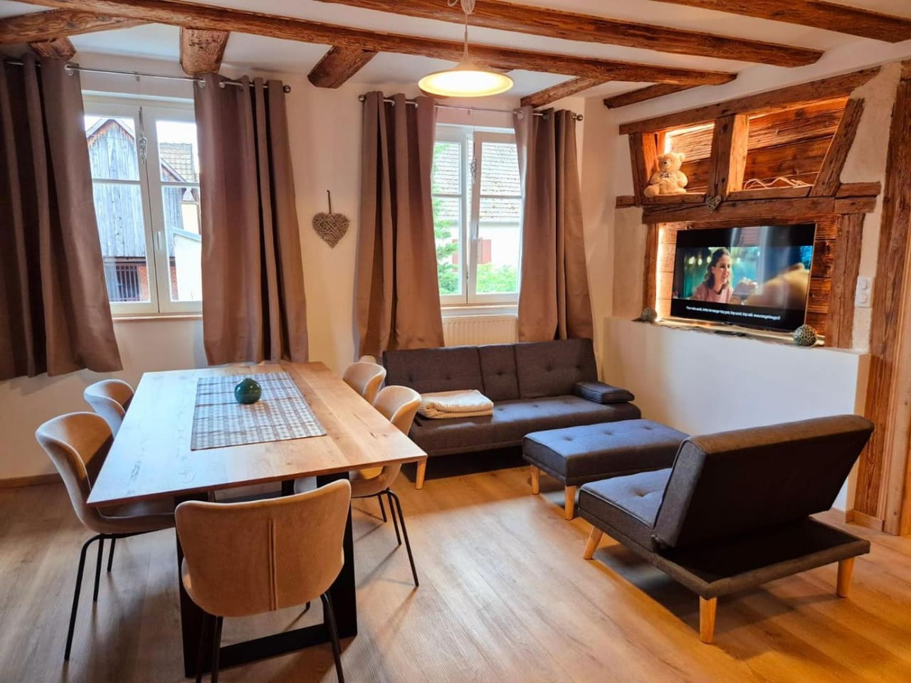 Wohnbereich der Ferienwohnung Au Cœur de l'Ours mit großem Holztisch und Sofa